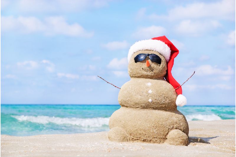 Boneco de neve de areia sorridente com chapéu de Papai Noel
